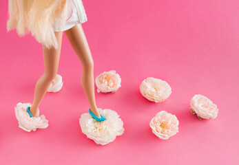 Girl with blue shoes on white roses on a pastel pink background. Creative minimal fashion concept.