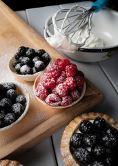 Cooking tarts with fresh berries in garden.