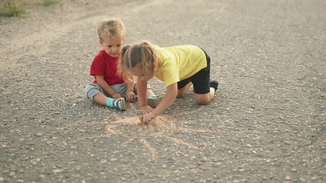 Happy child draw with chalk on asphalt in park. Child play and paint house and sun. Happy family concept Dream of home. Kid dream in park. Concept of kid dream of home. Chalk drawing of sun