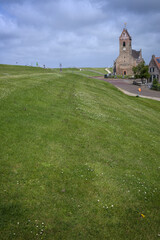 Church tower and dike at Waddenzee coast Wierum Friesland Netherlands. Village.