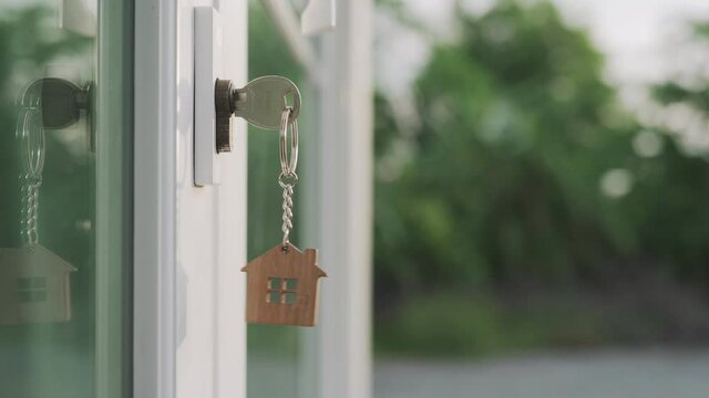 landlord for new home concept. New home for life The house key for unlocking a new house is plugged into the door. The  keychain was moving as the wind on evening.