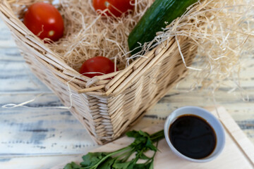 Vegetables on the table and in a basket, tomatoes, cucumbers, avocado, garlic and olive oil, vegetarianism, healthy eating