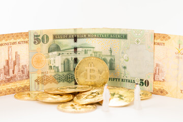 Saudi Arabian riyals, Bitcoin and Arabian businessman miniatures