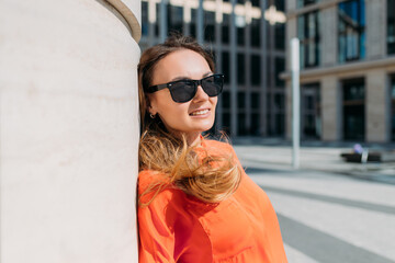 Portrait of a Caucasian girl in sunglasses and casual clothes in a summer city