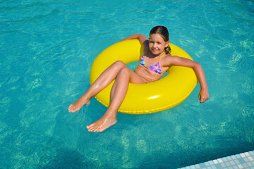 Real adorable girl relaxing in swimming pool