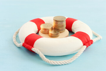 Concept image of lifebuoy and stack of coins. idea and metaphor of financial support in times of...