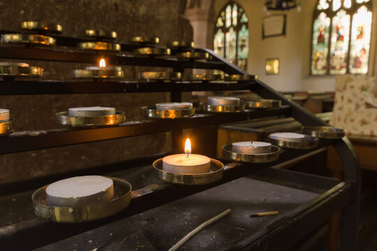 Votive candles lit as prayers for loved ones inside a Christian church