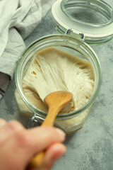 Sourdough starter in a jar, yeast-free leaven starter for healthy organic rustic bread, home baking concept