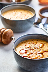 Lentil turkish yellow-coloured cream soup in a grey bowl. The second bowl is on the background. 45 angle view