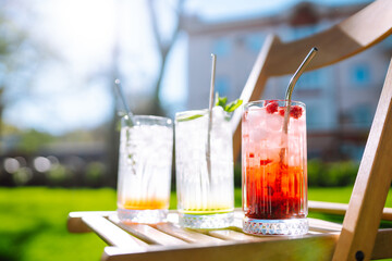 Alcoholic and non-alcoholic summer drinks with ice cubes of lemon, lime, fruits and mint. Summer holiday tropical concept.