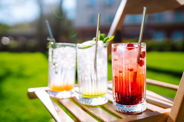 Alcoholic and non-alcoholic summer drinks with ice cubes of lemon, lime, fruits and mint. Summer holiday tropical concept.
