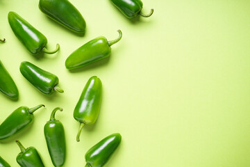 Jalapeno chili peppers, on a green background, space for text. Flat lay.