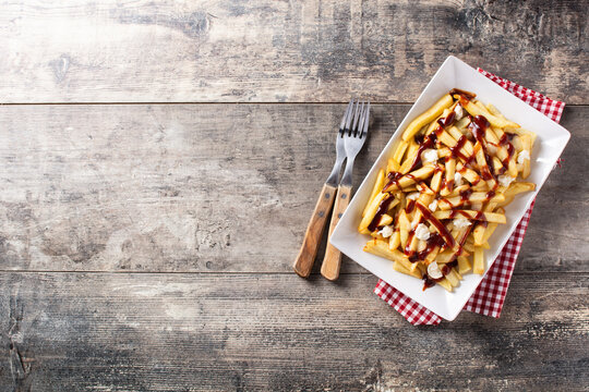 Traditional Canadian Poutine on wooden table. Top view. Copy space