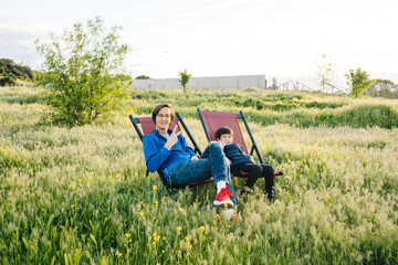 Father and son relaxing in folding hammocks