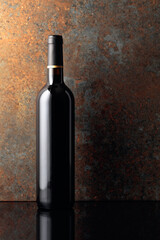 Bottle of red wine on rusty brown background.