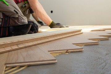 Handwerker bei der fachgerechten Verlegung von Fischgrätparkett