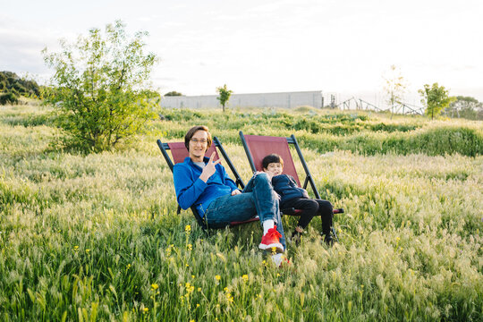 Father and son relaxing in folding hammocks