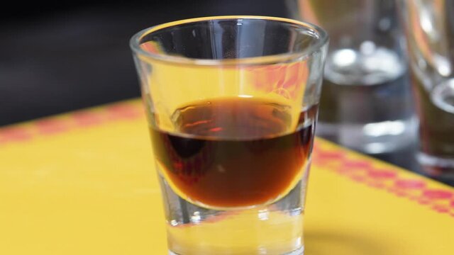 Bartender Pouring Brown Liquor in a Shot Glass Preparing A B-52 Cocktail Shot. - Closeup Shot