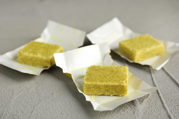 Bouillon cubes with wraps on light grey table, closeup