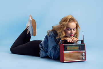Portrait of attractive young girl in retro 90s fashion style, outfits posing isolated over blue...