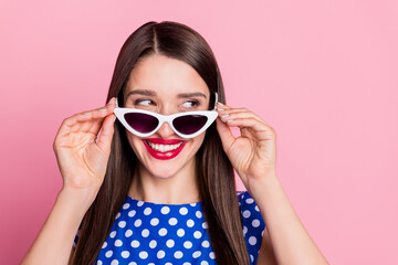 Portrait of attractive cheerful glamorous girl touching specs thinking copy space isolated over pink pastel color background