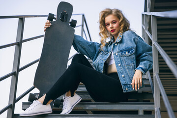 Beautiful adorable young girl in retro 90s fashion style, outfits posing on stairs, outdoors....