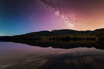 Fototapeta na wymiar Starry night sky. The milky way is reflected in the lake. The mountains are sleeping peacefully. 