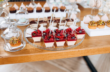 Candy bar. Beautiful multi colored decorated candy table baked sweet tasty cupcake cupcakes on a party. Beautifully decorated catering banquet table with different candy sweet delicacy.