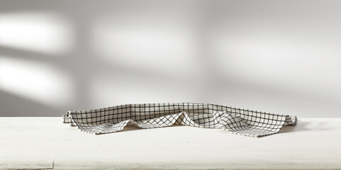 Desk of free space with napkin and wall with shadows 