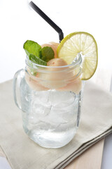 cold iced lychee fruit juice with lemon mint leaf in glass jar white background asian beverage halal menu
