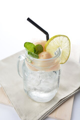 cold iced lychee fruit juice with lemon mint leaf in glass jar white background asian beverage halal menu