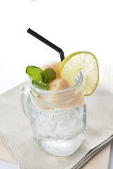 cold iced lychee fruit juice with lemon mint leaf in glass jar white background asian beverage halal menu