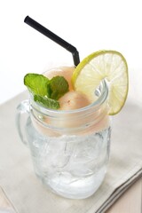 cold iced lychee fruit juice with lemon mint leaf in glass jar white background asian beverage halal menu
