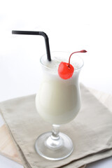cold iced organic soybean milk drink with red cherry in glass cocktail white background asian beverage halal menu