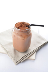 cold iced chocolate milo dinosaur with coco powder in glass jar white background asian beverage...