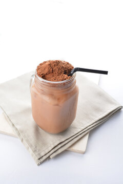 cold iced chocolate milo dinosaur with coco powder in glass jar white background asian beverage halal menu