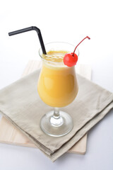 cold iced orange fruit juice with red cherry in cocktail glass white background asian beverage halal menu