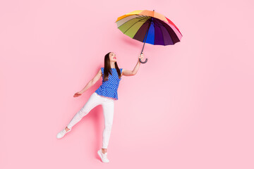Full length body size view of attractive cheerful carefree girl holding parasol having fun dancing isolated over pink pastel color background © deagreez