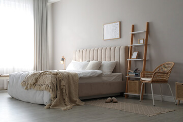 Cozy bed with soft linens in light room
