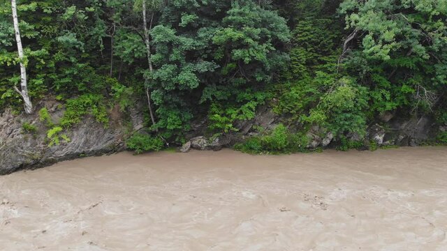 Mountain river after heavy rains. The water in the river is dirty from soil and stones. This situation is the forerunner of flooding in Europe.