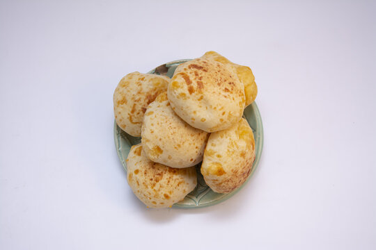 Top view of a clay plate on an isolated white background with traditional Paraguayan chipa bread