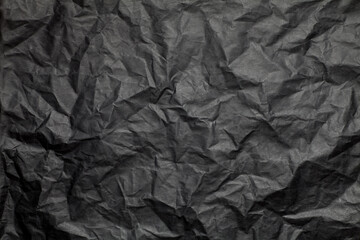 Crumpled black paper texture background.