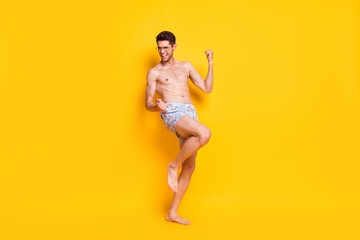 Fototapeta na wymiar Full length body size view of attractive shirtless cheerful guy dancing weekend day isolated over bright yellow color background