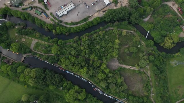 Top down sliding footage of green park between two rivers, nature in town. Fly above Middlesex filter beds nature reserve. London, UK