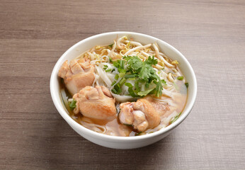 cook hot clear soup bowl with chicken drum stick and vermicelli noodle mee and vegetables in wood background healthy asian halal menu