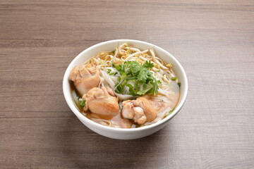 cook hot clear soup bowl with chicken drum stick and vermicelli noodle mee and vegetables in wood background healthy asian halal menu