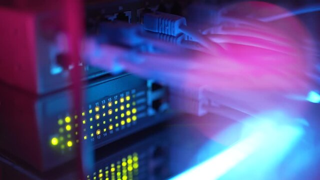 Close up fiber optic in server room. Network cables installed in the rack at data center. Ethernet cable on network switches background