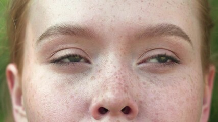 The red-haired girl opens her beautiful blue eyes. Close up of a girl's face. Gorgeous young woman with freckles and attractive looks. Natural beauty with freckles - Powered by Adobe