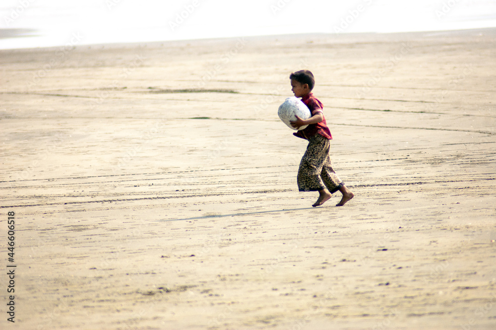 Sticker Boy running joyfully with a ball on the sandy beach