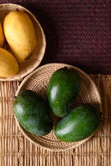 Raw and ripe mango fruit in a basket, Tropical fruit